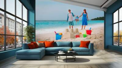 family beach vacation- sand castle and family at sea Wall mural