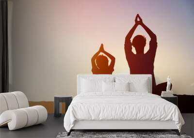 father and son doing yoga at sunset Wall mural