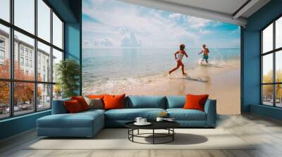 happy little girl and boy run and play with water at beach Wall mural