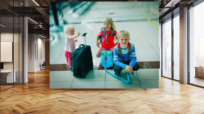 kids- boy and girls- with luggage waiting in airport, family travel Wall mural