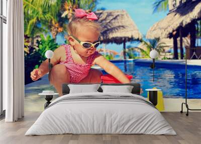 little girl playing in swimming pool at tropical beach Wall mural