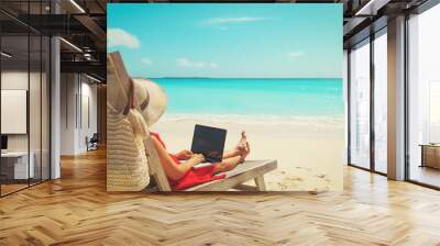 remote work concept -young woman with laptop on beach Wall mural