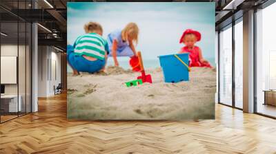 toys and kids -boy and girls- playing on beach Wall mural