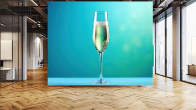  a close up of a wine glass with a liquid inside of it on a blue surface with a blurry background of a green and blue hued back ground. Wall mural