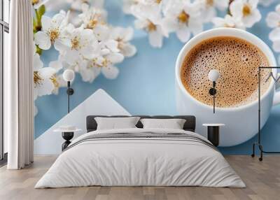   A coffee cup atop a table with white flowers on a blue background Wall mural