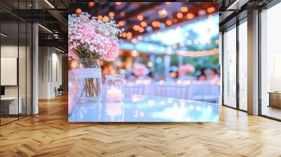  A vase holding pink and white flowers rests atop a table near two lit candles Wall mural