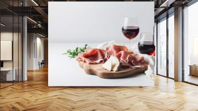  a wooden cutting board topped with meat and cheese next to two wine glasses.  generative ai Wall mural