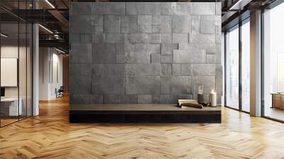  a wooden table topped with two candles next to a wall covered in blocks of grey tiles and a candle holder. Wall mural