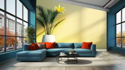   A yellow plant in a white vase against a yellow wall with a palm tree shadow in front Wall mural