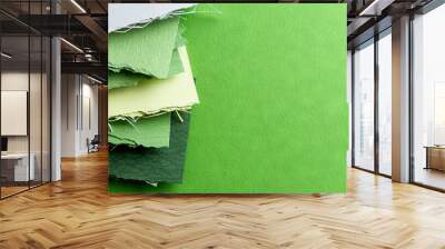   Green and white paper on a green surface with a white piece protruding Wall mural