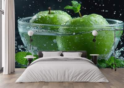   Two green apples in a glass of water with a splash of water and a green leaf on top Wall mural