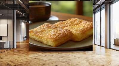   Two slices of bread rest on a plate beside a cup of coffee on a table near a window Wall mural