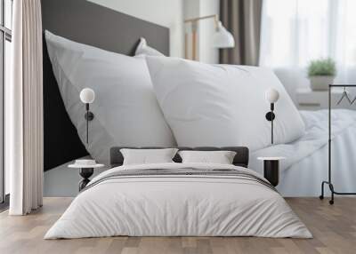  two white pillows sitting on top of a bed next to a night stand with a potted plant on the side of the bed and a lamp on the other side of the bed. Wall mural