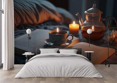 a tea cup and a book on a bed with a teapot and candles in the background and a teapot on the bed wi Wall mural