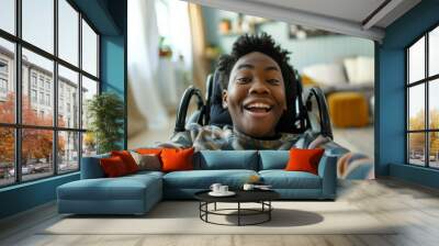 Phone selfie made by smiling african american boy sitting in the wheelchair with natural soft light and colors in his home on the background Wall mural