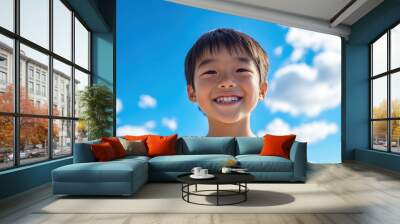 Smiling asian kid boy against bright blue sky on the background. Summer vacation concept photo. Wall mural