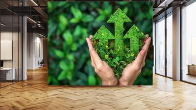 human hands holding green arrows made of plants. green economy concept Wall mural