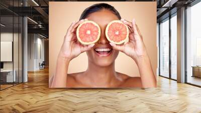 Grapefruit, beauty and eyes of happy woman in studio, vitamin c nutrition or natural glow. Face of female model, healthy skincare or smile with citrus fruits, eco dermatology or sustainable cosmetics Wall mural