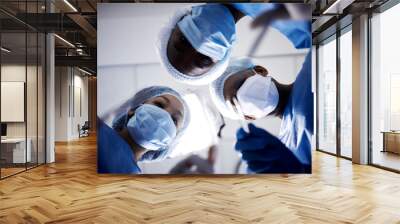 Surgery, low angle or doctors with face mask, scissors or surgical procedure or healthcare in hospital clinic. Teamwork, medical safety tools or surgeons working in gloves helping in operating room Wall mural