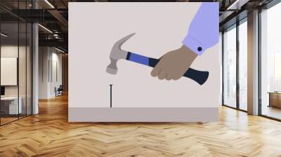 A hand holding a hammer and hitting a metal nail, a carpenter manual work Wall mural