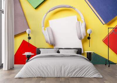 Audio books concept. Headphones and color books at yellow background. Flat lay image with copy space. Wall mural