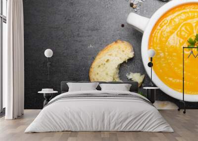 Carrot cream-soup on black table. Long banner format. Wall mural