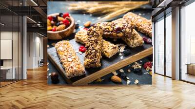 Granola bar with nuts, fruit and berries on black. Wall mural