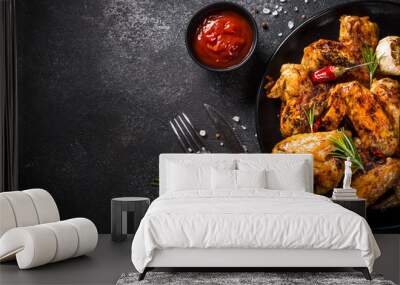 Grilled chicken wings with spices at black table. Top view with space for design. Wall mural