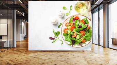 Salad from green leaves and vegetables. Fresh green salad in white plate. Top view. Wall mural