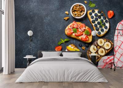 Sweet toast assortment with fresh fruit and berries on black. Wall mural