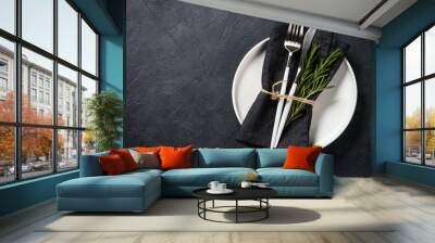 White plate, cutlery and napkin on black table top view. Wall mural