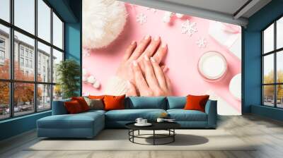 Woman using winter cream for hands. Wall mural