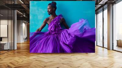 african male model in purple dress posing against blue background, high fashion portrait with bold colors and dramatic lighting Wall mural