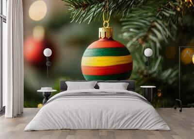 christmas tree ornament with red, green, and yellow stripes hanging on an evergreen branch, with a blurred background highlighting the colorful festive decoration in high-resolution photography Wall mural