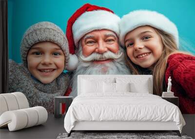 close-up portrait of santa claus with a smiling boy and girl on a blue background, capturing a cheerful and joyful holiday atmosphere in a studio shot with a focus on family happiness Wall mural