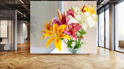 A bouquet of lilies in a vase in daylight Wall mural