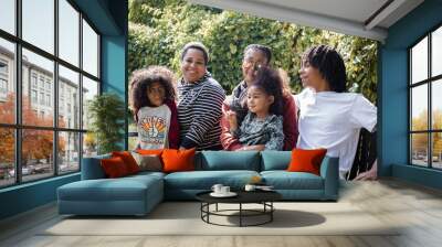 African American family relaxing on bench in park in fall  Wall mural