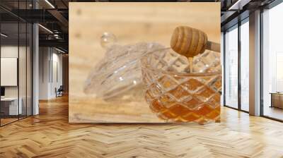 glass bowl with honey and honey dipper on a wooden table Wall mural