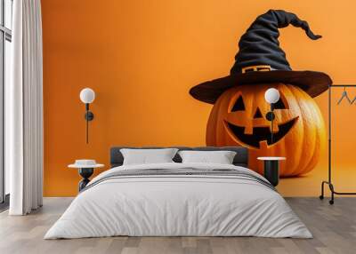 Halloween pumpkin wearing a witch's hat on orange background Wall mural