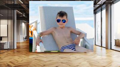 Young boy in a swimsuit on a shelf by the pool Wall mural