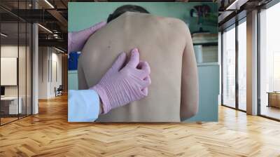 Doctor checks posture of little girl in clinic Wall mural