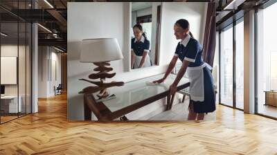 Hotel service. female housekeeping worker with cleaning table from dust in room concept Wall mural