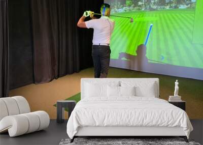 Professional male golfer holding club playing golf indoors on golf simulator Wall mural