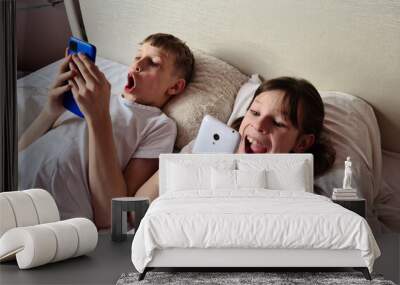 Surprised shocked kids with mobile phone play online games Wall mural