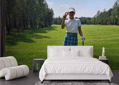 Woman Holding Golf Ball on Green Course During Summer Day Wall mural