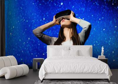 a beautiful girl wearing a virtual reality device, standing on the background of the sky Wall mural