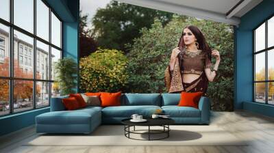 Portrait of beautiful indian girl . Young hindu woman model with tatoo mehndi and kundan jewelry. Wall mural