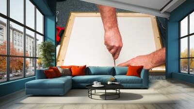 Craftsman working on frame in frame shop. Professional framer hand holding frame angle. Top view. Copy space Wall mural