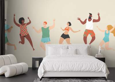 Cheerful happy young people in beachwear and swimsuits jump on the beach Wall mural