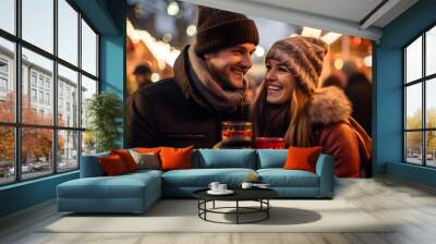 On a winter night,  young couple enjoying drinks and lively conversation. In the background, the brightly lit Christmas market sets the festive scene Wall mural